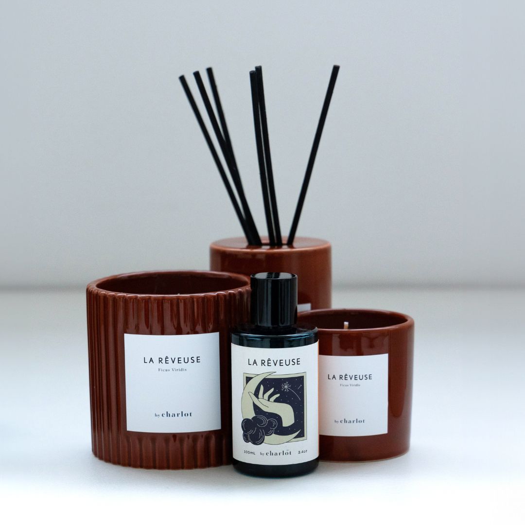 Refill bottle for The Dreamer, in front of The Dreamer diffuser and candle